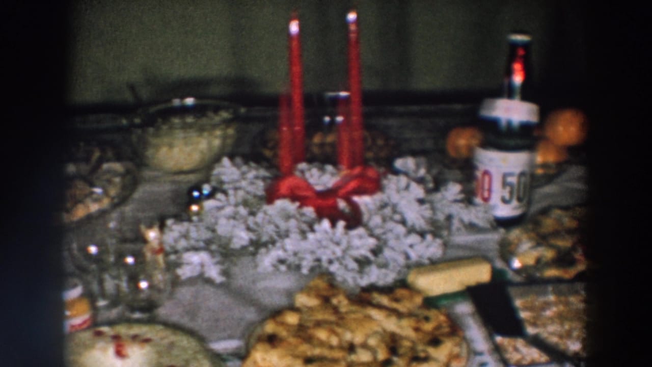 Holiday table with red candles, white centerpiece material, food, oranges, and a 50/50 soda bottle.