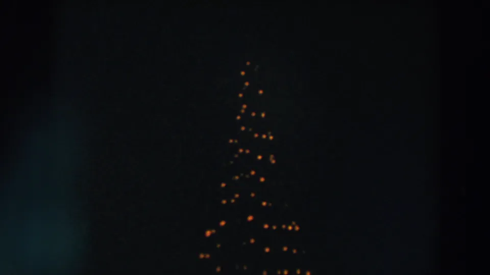 A dark 1957 Wheeling, Ohio frame showing triangular warm string lights with a short row of smaller lights nearby.