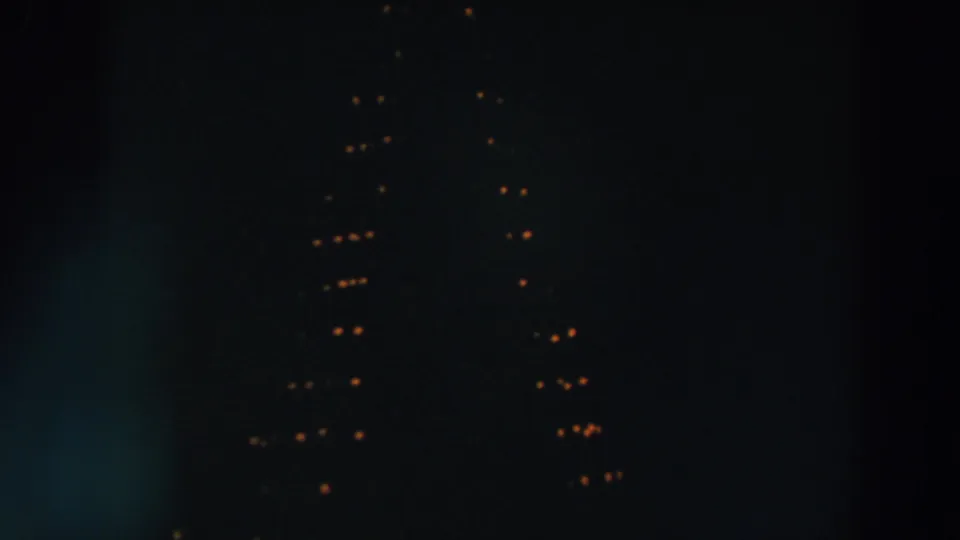 1957 Wheeling, Ohio nighttime home-movie frame with faint warm holiday lights and soft vertical flare.