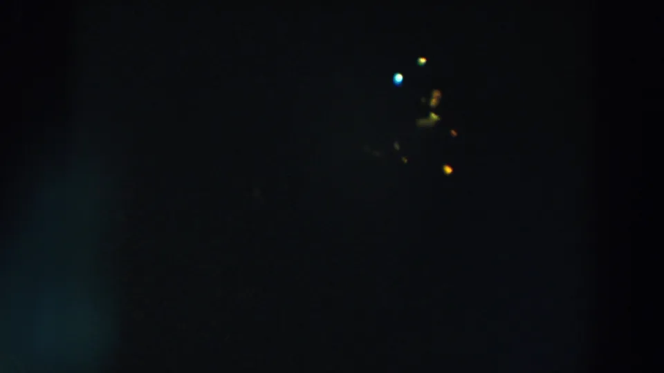 1957 Wheeling, Ohio night frame with small distant blue, yellow, and orange lights emerging from darkness.
