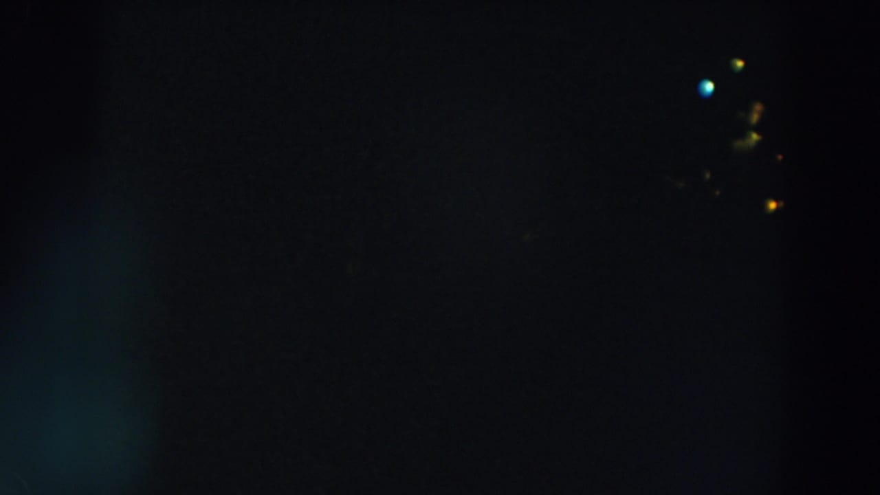 1957 8mm home-movie frame from Wheeling, Ohio, showing small red, yellow, and blue lights against a dark night field.