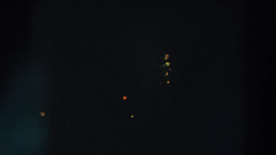 Dark 8mm night view from Wheeling, Ohio, with scattered yellow and orange lights and faint lens glow.
