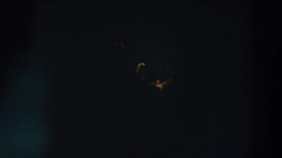 Extremely dark 8mm frame from Wheeling, Ohio, with a faint yellow light visible high in the night sky.