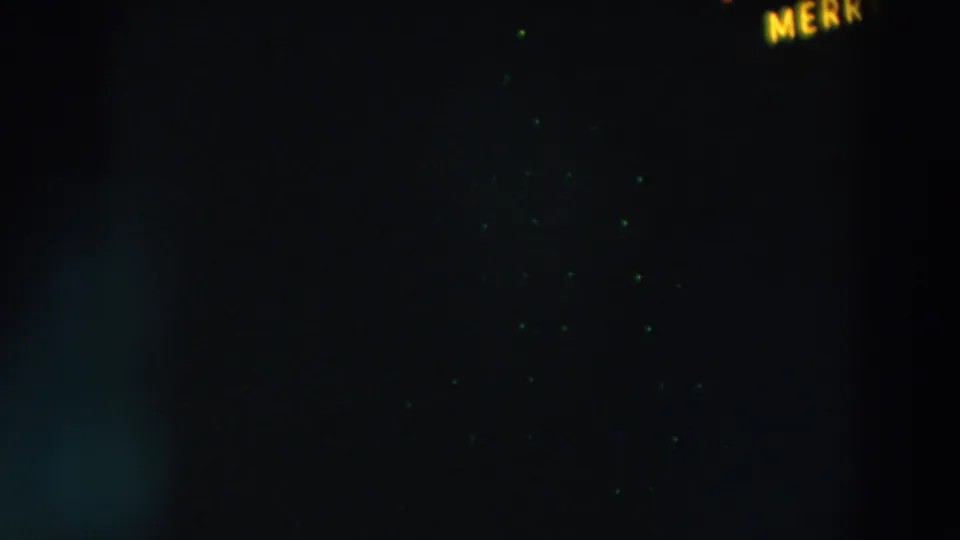 1957 Wheeling, Ohio night footage with scattered green lights and partial yellow lettering visible near the upper right edge.