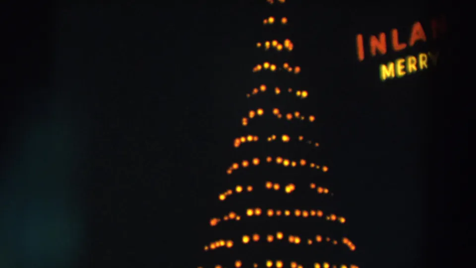 The 1957 Wheeling holiday display shows rows of glowing bulbs on a conical tree shape at night.