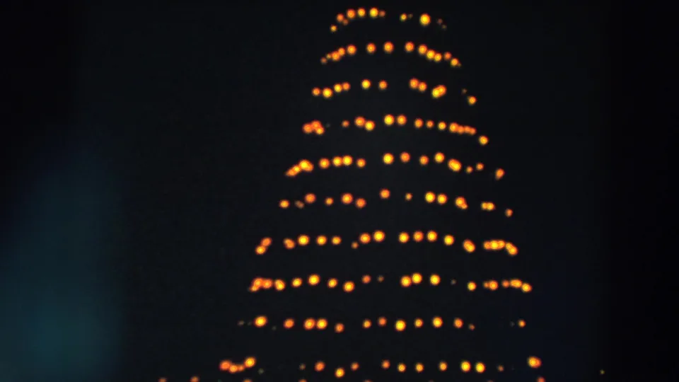1957 Wheeling, Ohio 8mm view of a revolving Christmas tree light display with low-light softness.