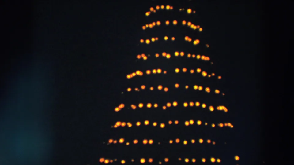 1957 Wheeling, Ohio night frame showing a compact yellow Christmas tree light pattern on 8mm film.