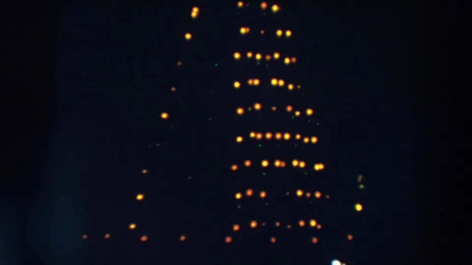1957 Wheeling, Ohio frame with a soft, rotating-looking arrangement of yellow and green lights in darkness.