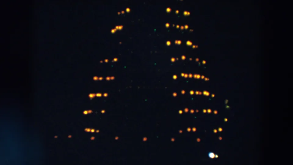 1957 Wheeling, Ohio frame showing clustered yellow lights and faint green points on a dark, possibly rotating structure.