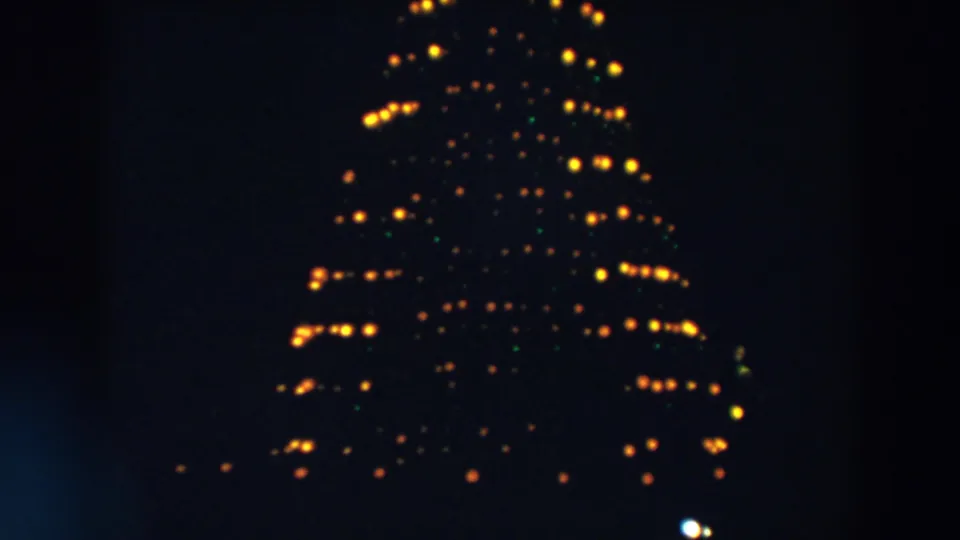 The 1957 Wheeling, Ohio frame shows a tall triangular light formation, with yellow bulbs and faint green points in soft focus.