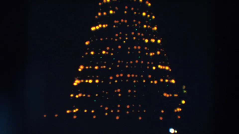 A dense triangular cluster of yellow bulbs, with a few green lights, appears in this Wheeling, Ohio 1957 night frame.