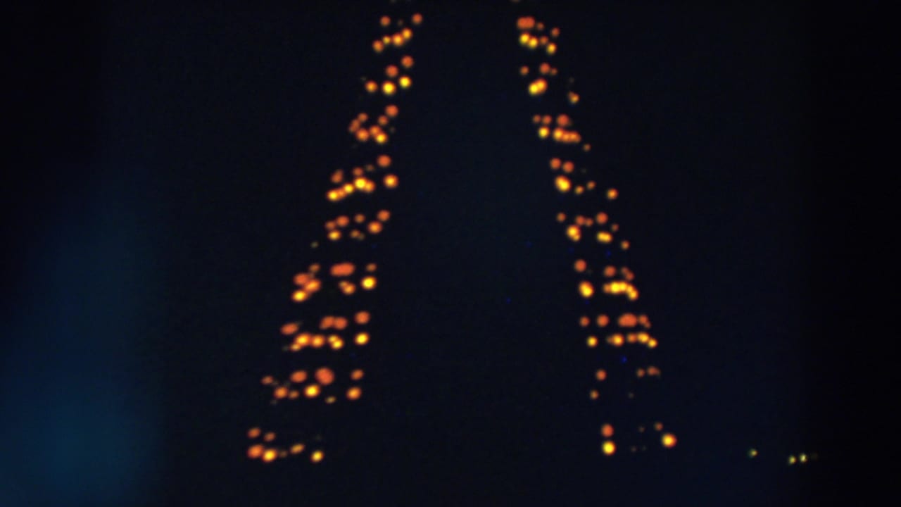 1957 Wheeling, Ohio frame with orange lights forming tall vertical patterns in the darkness.