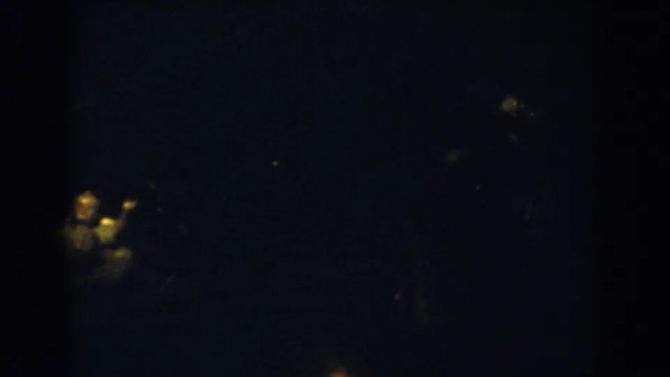 Dim 1957 Wheeling night frame with faint holiday lights and part of the illuminated tree near the right side.