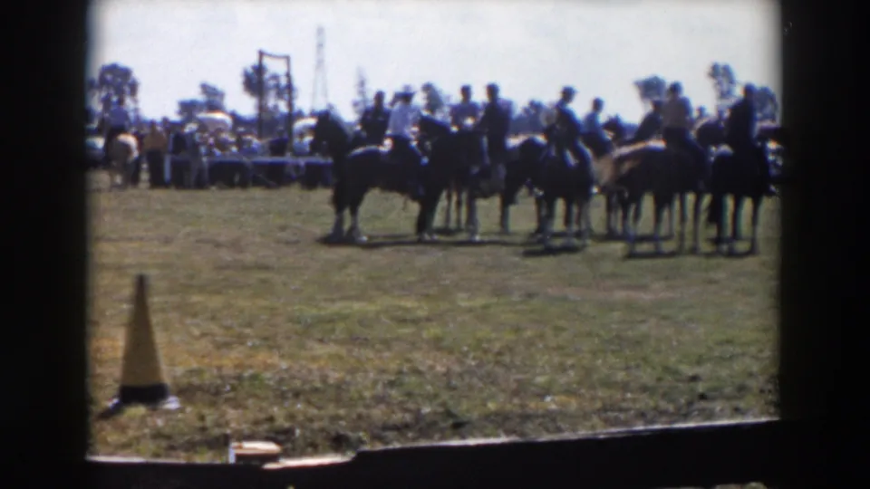 In the closing frame, several horseback riders remain grouped in the Wheeling, Ohio show ring, with spectators and event tables behind them.