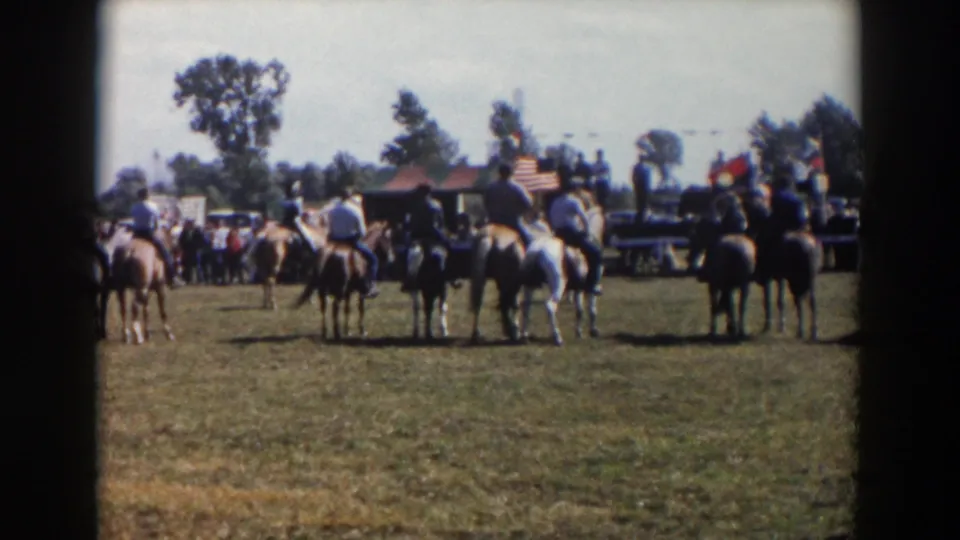 Final frame shows the mounted group still in place in Wheeling, Ohio, with spectators, flags, trees, and open grass visible through 8mm film borders.