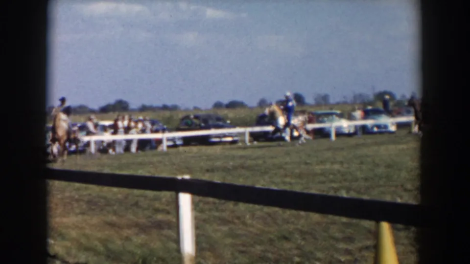 A wider 1957 fairground view shows horses near a white rail fence, parked mid-century cars, and spectators in the distance.