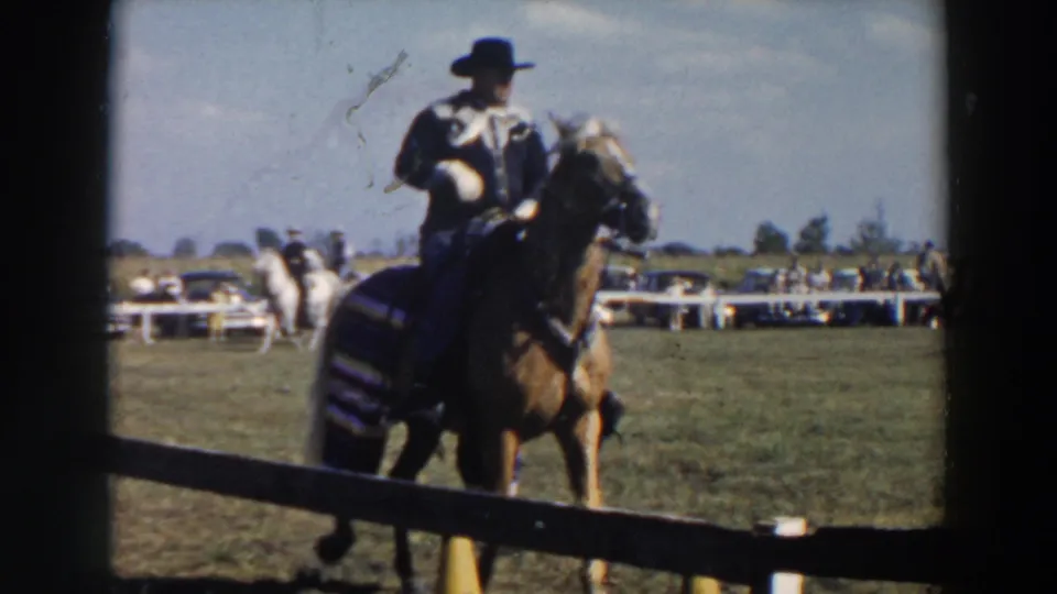 Close home-movie view of a mounted rider in western attire at a 1957 Wheeling, Ohio horse show.