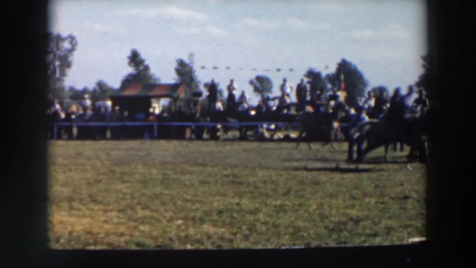 1957 Wheeling, Ohio 8mm frame showing a horse and rider entering a cone-marked field course as spectators watch from behind a barrier.