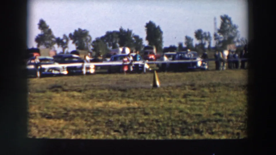 Spectators and mid-century cars line the grassy perimeter during the 1957 Wheeling, Ohio horse show.