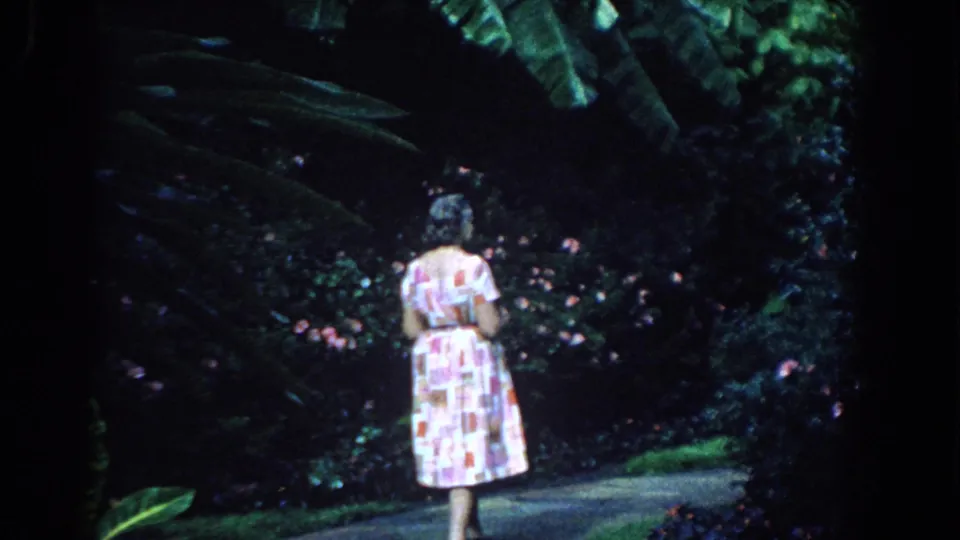A rear view shows the woman walking deeper into the tropical garden, with 8mm softness and saturated greens.