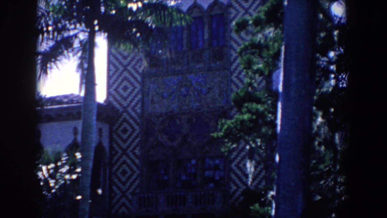 1958 Florida 8mm frame showing palm trees in front of an ornate exterior with diamond-patterned decoration and shaded windows.