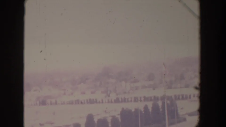 Faded 1958 Florida home-movie frame showing a soft distant landscape with open fields, tree lines, pale sky, and visible film borders.