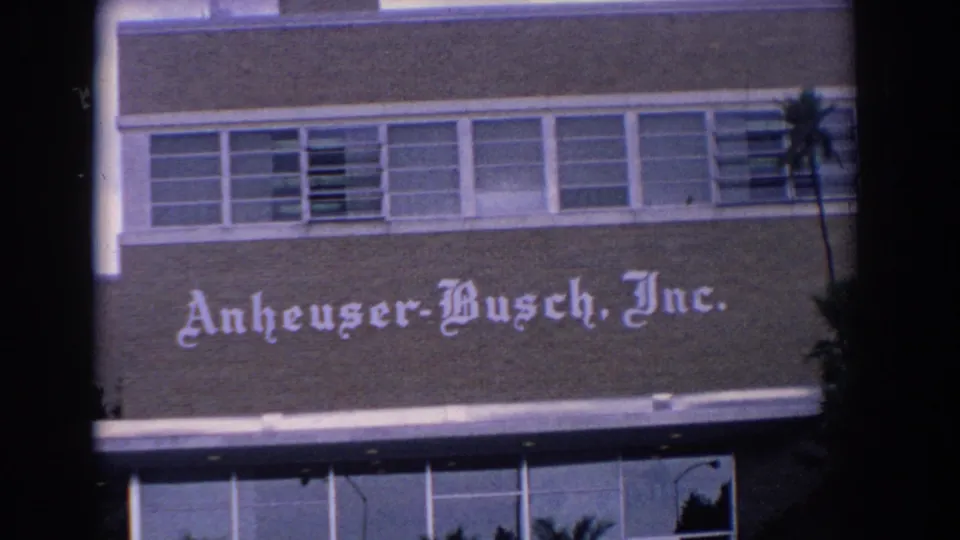 1958 Florida frame showing a closer exterior view of the Anheuser-Busch, Inc. name on brick beneath a long band of windows.