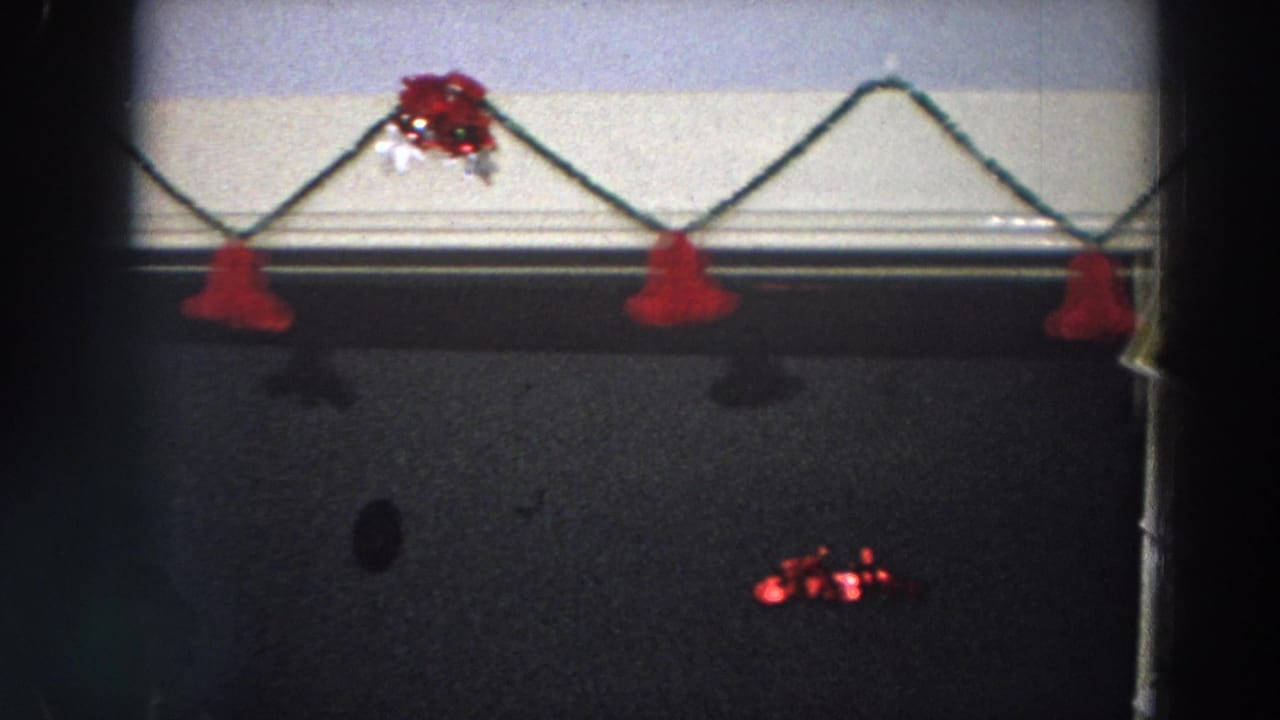 Dim 1958 Italy room detail with red hanging ornaments, tinsel, and dark wall surfaces below.