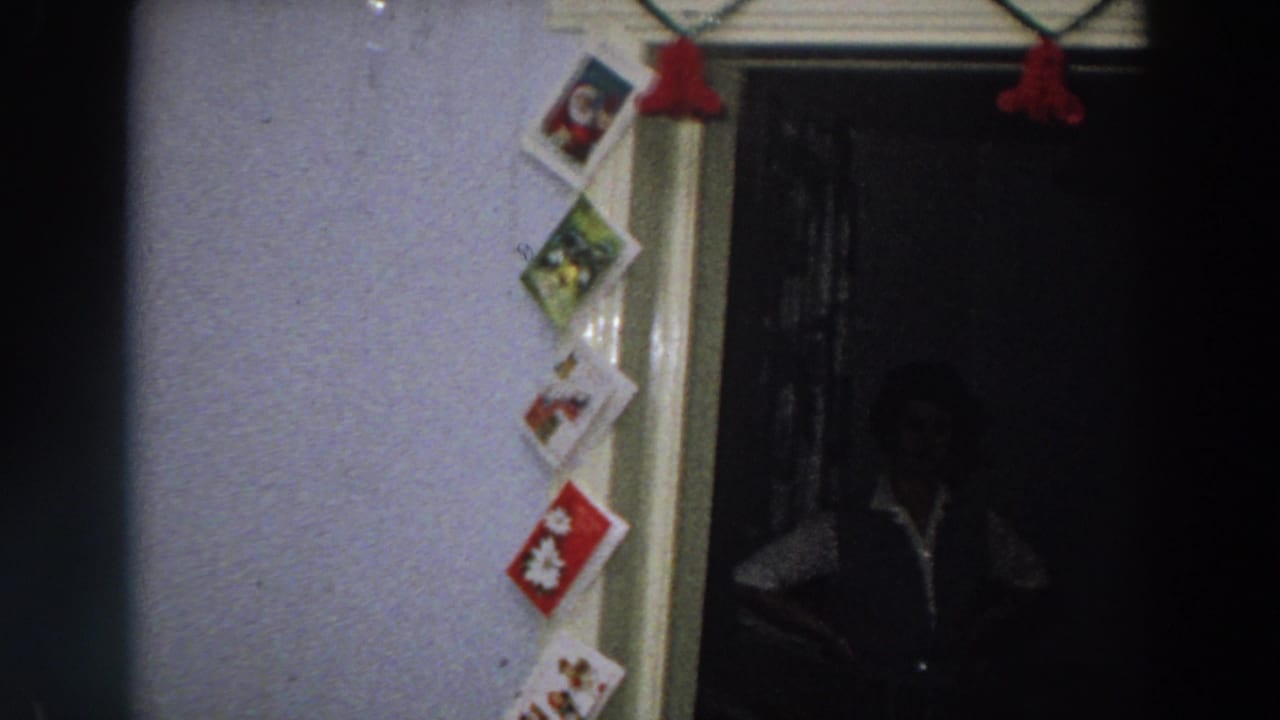 1958 Italy frame with a vertical display of holiday cards, pale trim, red tassels, and a darkened interior beyond the doorway.