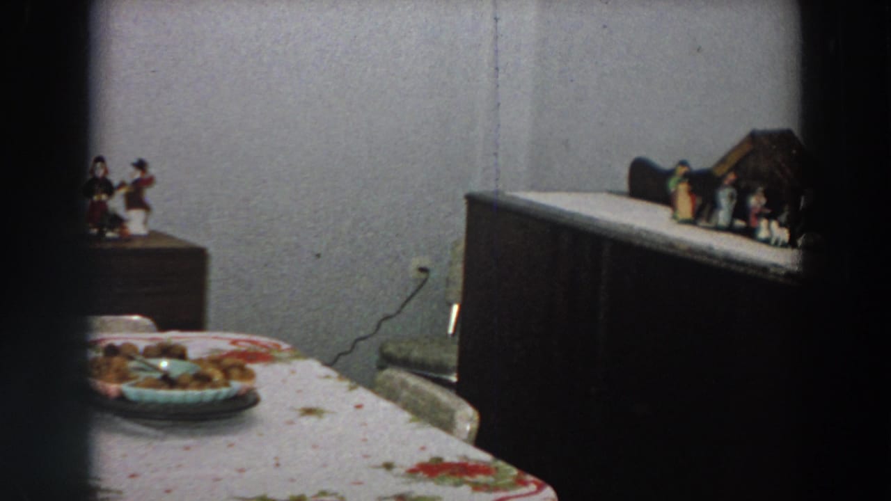 A 1958 Italian dining room view shows the table, food plate, wooden furniture, wall outlet, and small household decorations.