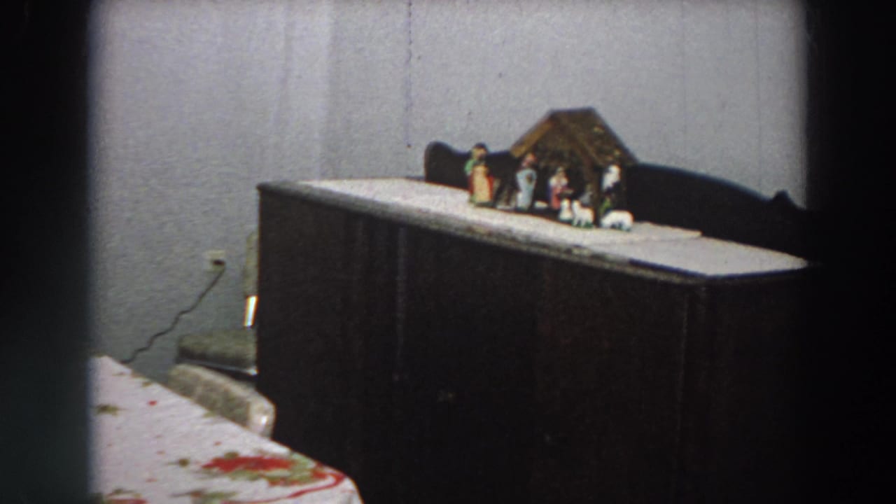 1958 Italian domestic interior with a small nativity scene arranged on a dark cabinet near a table edge.