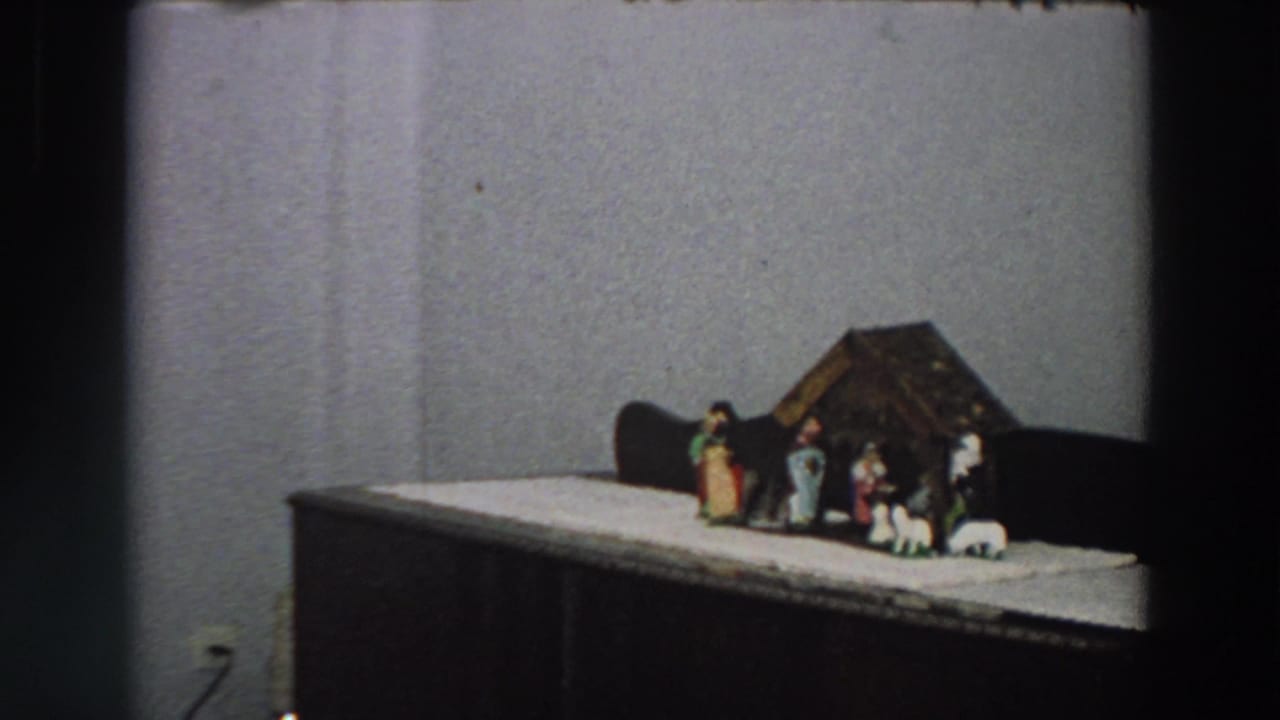 1958 Italy frame with a tabletop creche, small figures and sheep arranged on a white cloth.