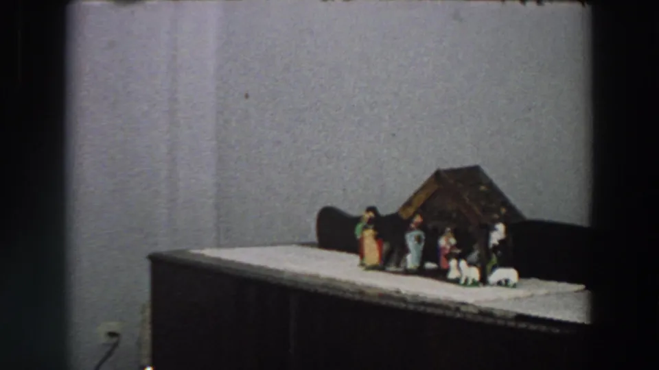1958 Italy frame with a tabletop creche, small figures and sheep arranged on a white cloth.