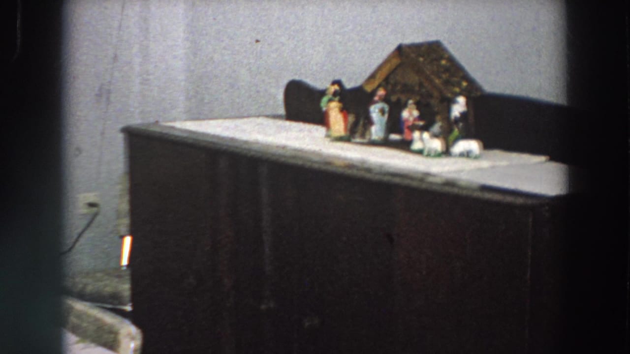 Wider 1958 Italy interior view showing the Christmas nativity scene set on a cabinet, with wall outlet and room furnishings partly visible.