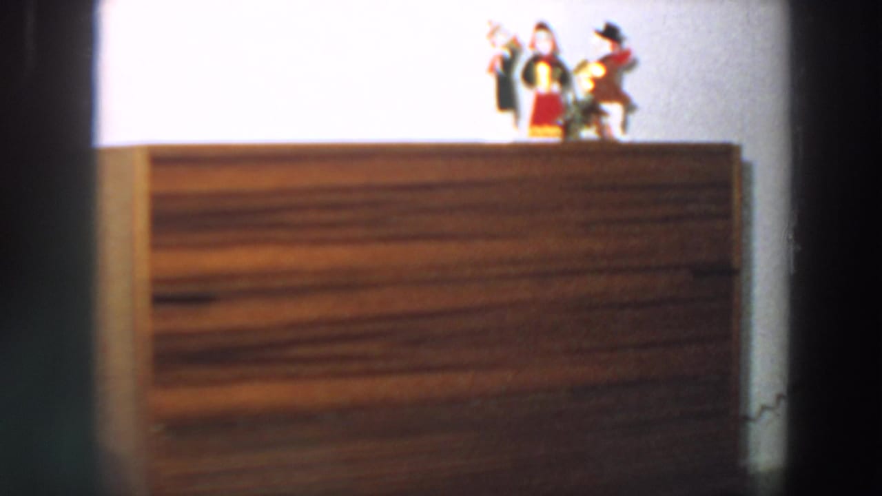 Mid-century Italian interior frame with a brown wooden console table and small decorative figurines on top.