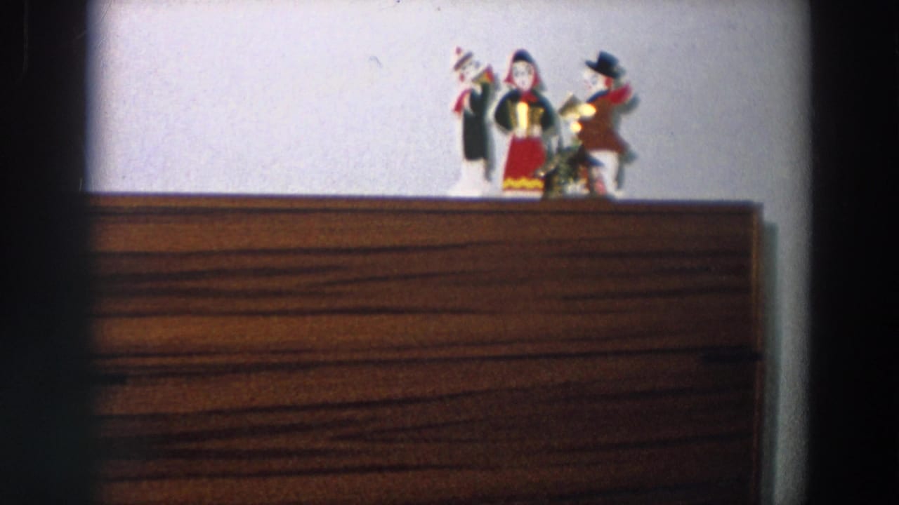 Close home-movie view of small decorative figurines arranged on a wooden console table in a 1958 Italian interior.