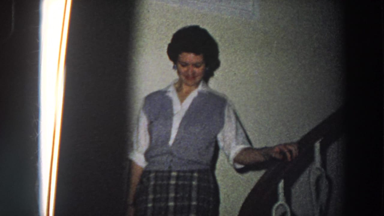 Woman descending stairs with her hand resting on a wooden railing.