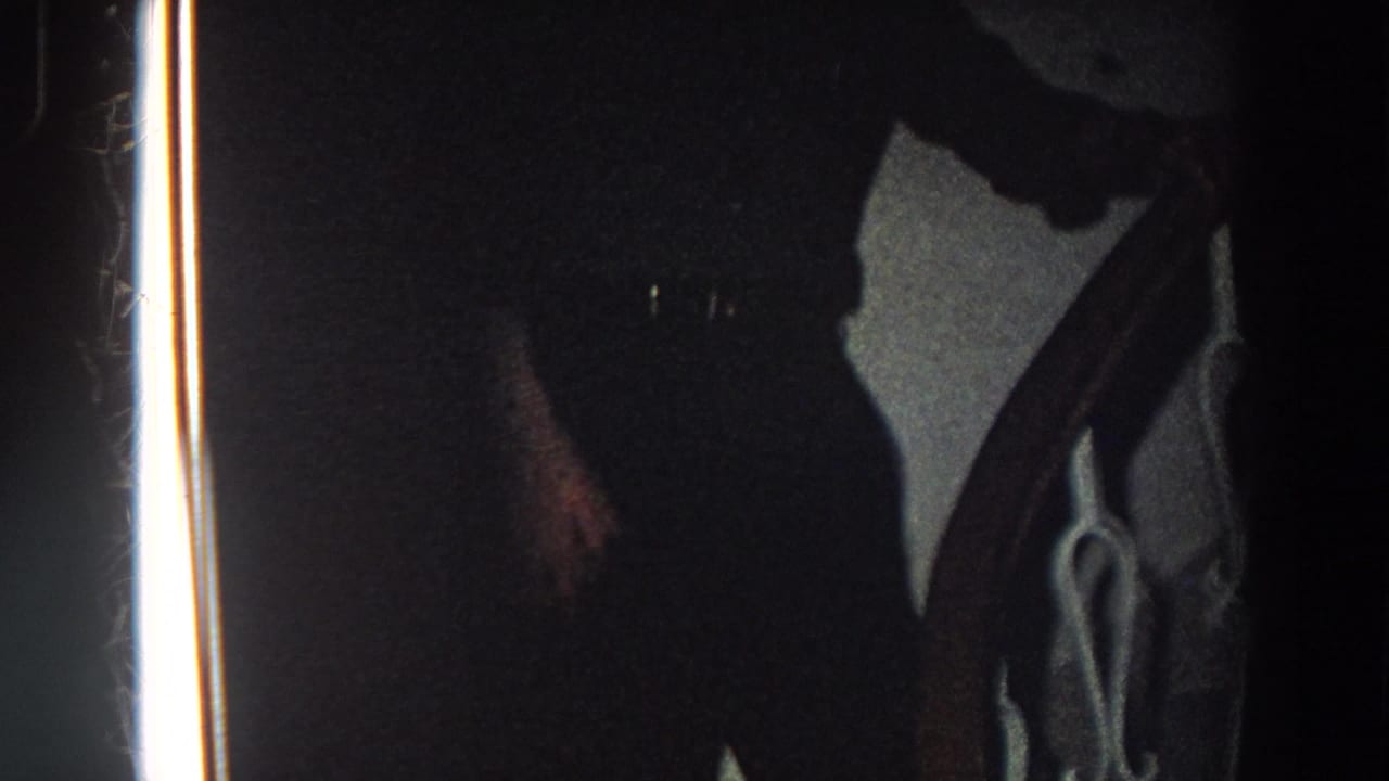 A shadowed lower-body view shows the man continuing down the stairway, with the rail and film edge prominent.