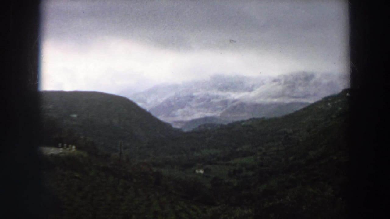 Misty mountain valley under a cloudy sky with dark 8mm frame borders.