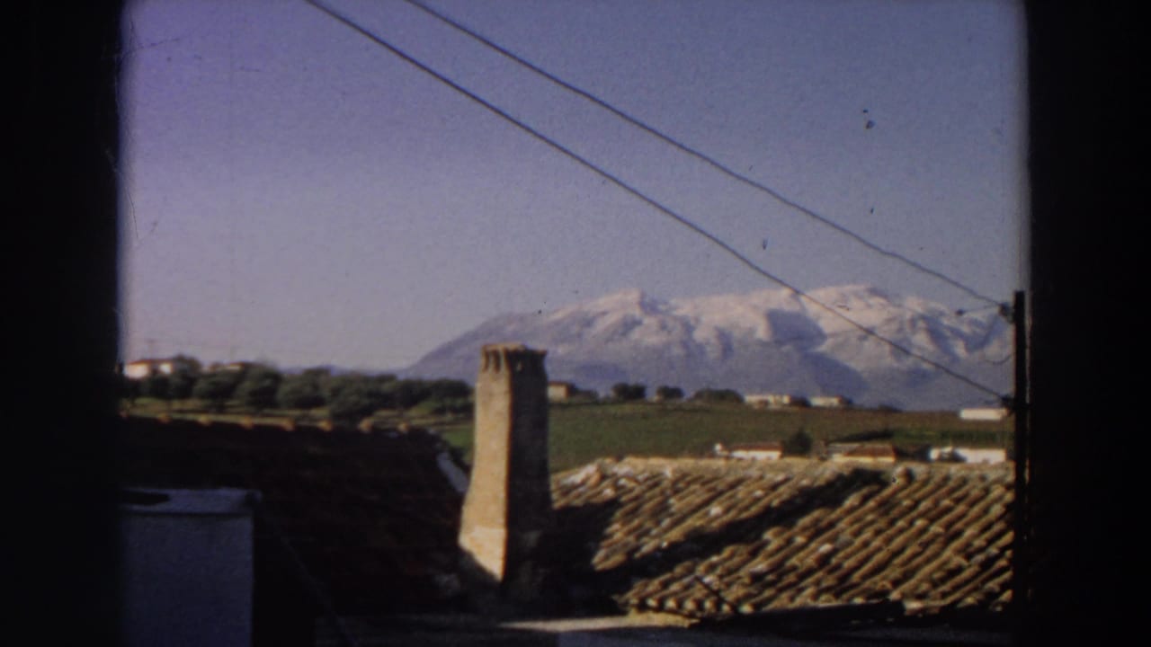 A second Italy landscape frame shows rooftops, a chimney, overhead wires, fields, and snow-capped mountains beyond the window.