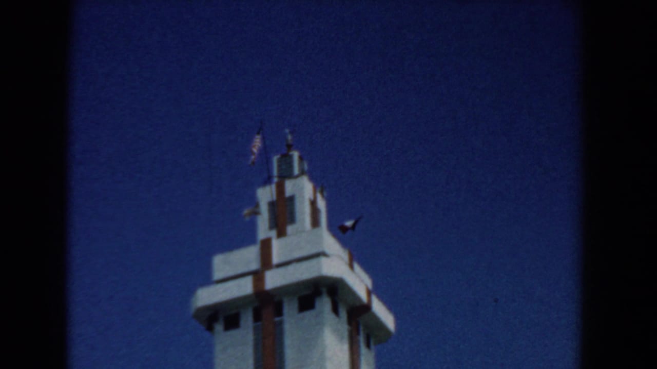 Low-angle view of a white stepped tower against a deep blue sky.