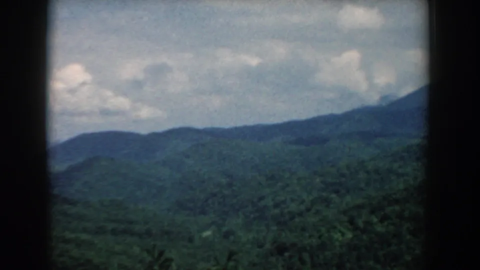 1958 South Carolina 8mm landscape frame with green mountain slopes, layered ridge forms, and visible dark film-frame edges.