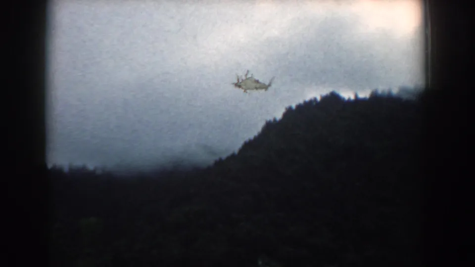 1958 8mm footage of a dark South Carolina hillside and cloudy sky, with a small visible film blemish near the center-left.