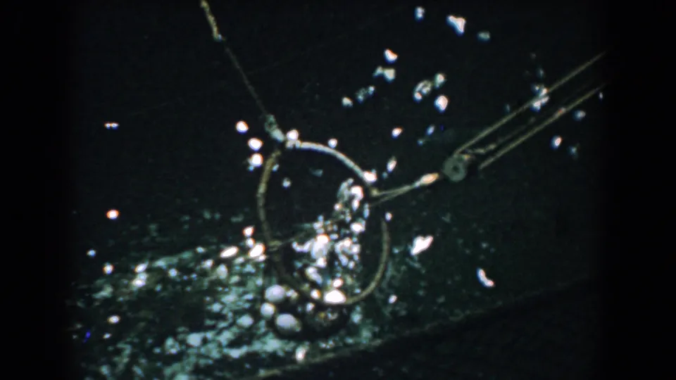 Final 1958 Yorktown frame showing fishing gear or netting against dark water, with strong reflections and handheld framing.