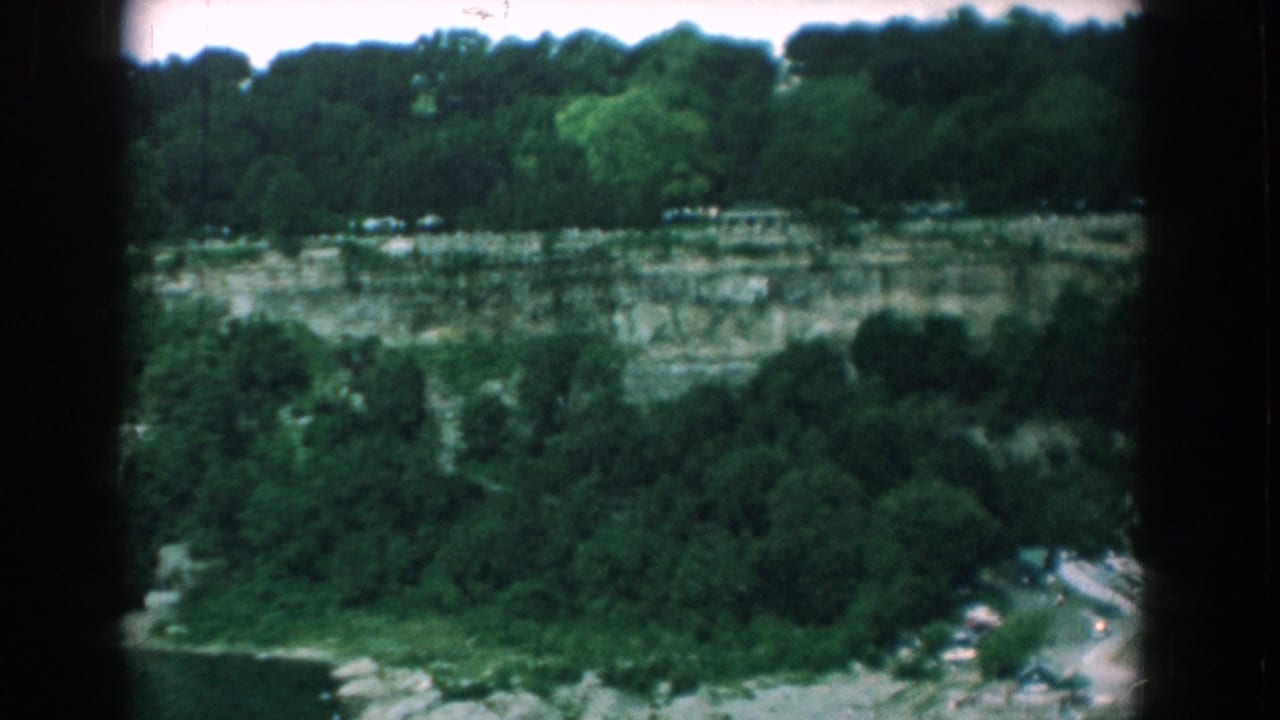 1958 Yorktown, Virginia home-movie view of layered quarry cliffs, trees, brush, and a glimpse of water below.