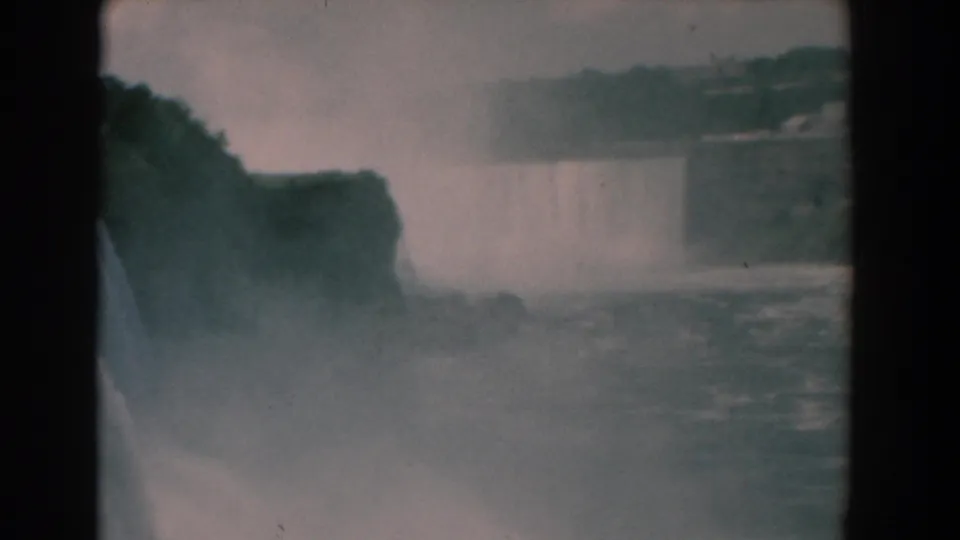 1958 8mm Niagara Falls frame with mist obscuring part of the gorge and a waterfall edge visible at left.