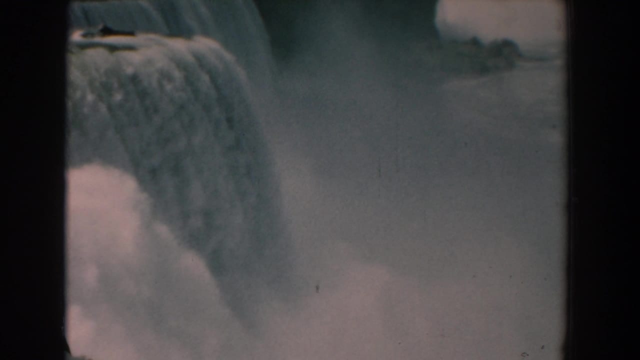 Wide view of the falls with heavy mist and dark film borders visible.