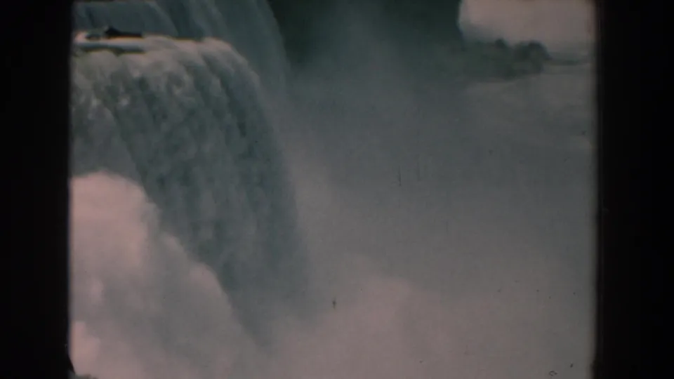 Archival 8mm view of American Falls at Niagara Falls, with water dropping over the edge into a hazy mist field.