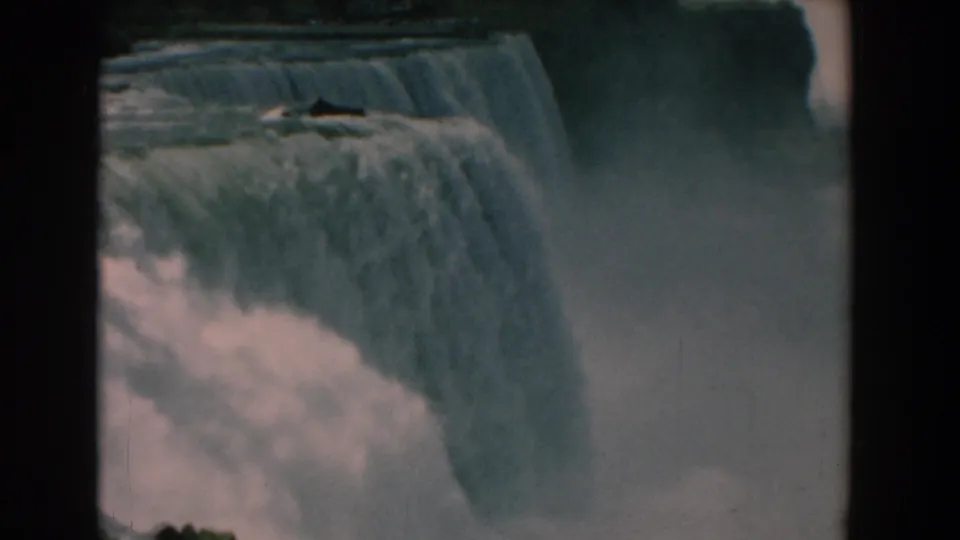 Final 8mm frame showing American Falls at Niagara Falls, with blue-gray water dropping into dense spray.