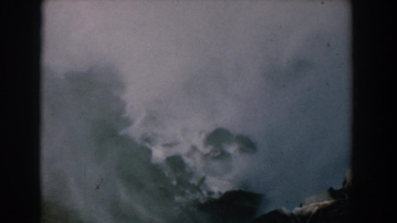 Misty waterfall spray seen through a dark 8mm film frame.
